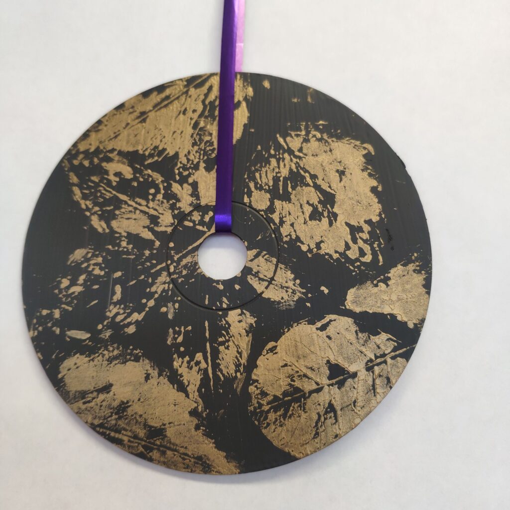 praca plastyczna przedstawiająca kompozycje złotych liści kalkomania na płycie CD