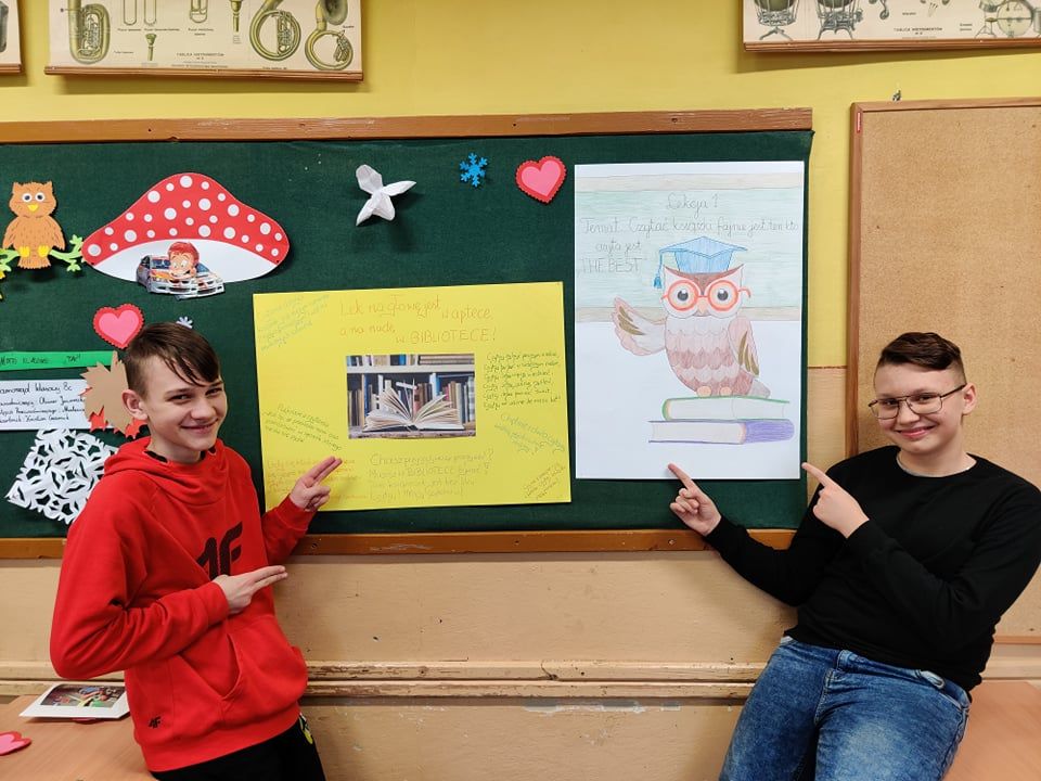 Dwóch uczniów prrezentuje plakaty zachęcające do czytania